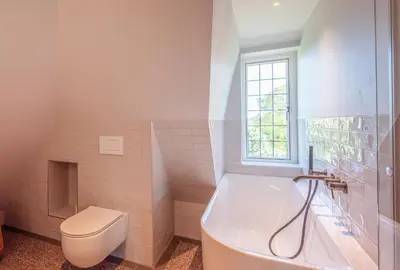 a bathroom with a tub and a toilet and a sink at De Kievit in Vogelenzang