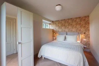 a bedroom with a bed with a floral wall at De Kievit in Vogelenzang