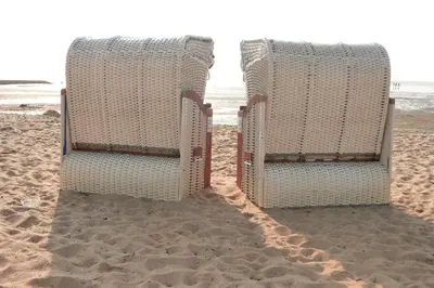 two beach chairs sitting on the sand on the beach at Zomerhuis Duinzicht in Egmond aan den Hoef