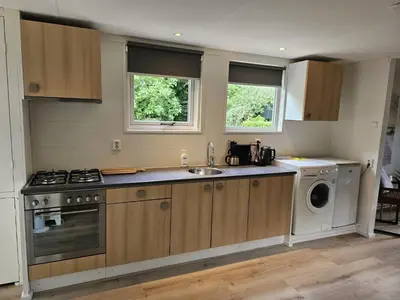 a kitchen with a sink and a washing machine at Zomerhuis Duinzicht in Egmond aan den Hoef