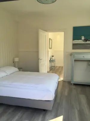 a white bedroom with a bed and a fireplace at Studio De Laan in Zandvoort