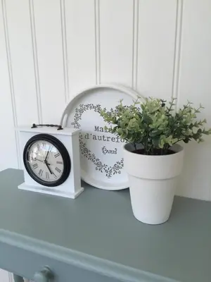 a table with a clock and a potted plant on it at Studio De Laan in Zandvoort