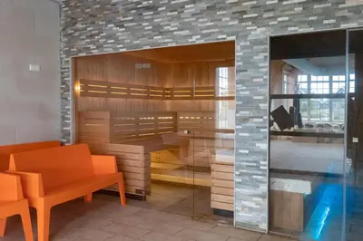 a room with a bench and a table and chairs at EuroParcs Poort van Amsterdam in Uitdam