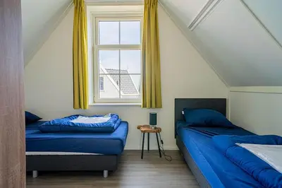 a bedroom with two beds and a window at EuroParcs Poort van Amsterdam in Uitdam