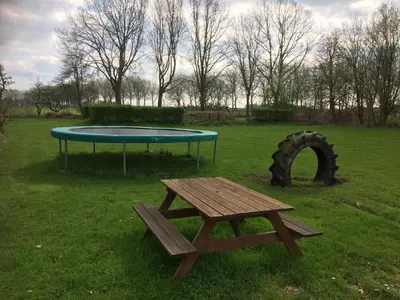a picnic table and a trampoline in a field at Rest & Rust in Werkhoven