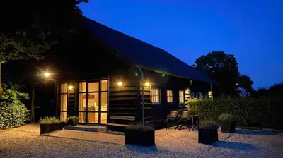 a cabin with a dark roof at night at Rest & Rust in Werkhoven