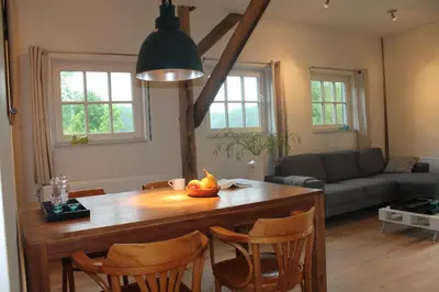 a kitchen and living room with a table and chairs at Rest & Rust in Werkhoven