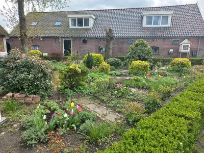a garden in front of a house with flowers at B&B De Kaagse Boer in Kaag