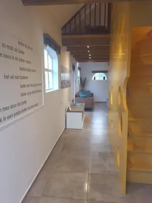 a hallway with a staircase and a living room at B&B De Kaagse Boer in Kaag