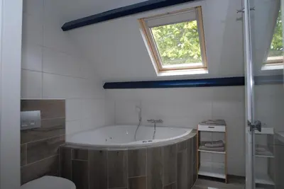 a bathroom with a bath tub and a window at B&B De Kaagse Boer in Kaag