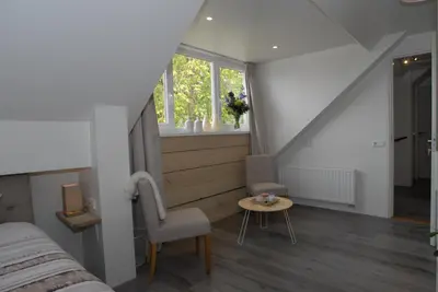 a bedroom with a bed and a window and a table at B&B De Kaagse Boer in Kaag