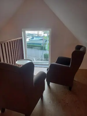 two chairs and a table in a room with a window at B&B De Kaagse Boer in Kaag