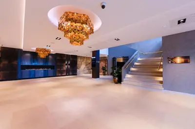 a large lobby with a chandelier and a staircase at Van der Valk Hotel Oostzaan - Amsterdam in Oostzaan