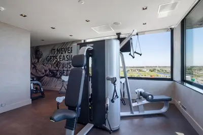 a gym with tread machines and a large window at Van der Valk Hotel Oostzaan - Amsterdam in Oostzaan