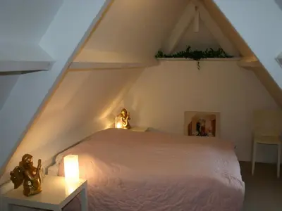 a bedroom with a white bed in a attic at Groet Villa Stay with Garden Views in Groet