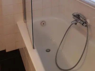 a shower with a shower head in a bathroom at Groet Villa Stay with Garden Views in Groet
