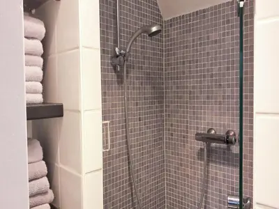 a bathroom with a shower with blue tile at Groet Villa Stay with Garden Views in Groet