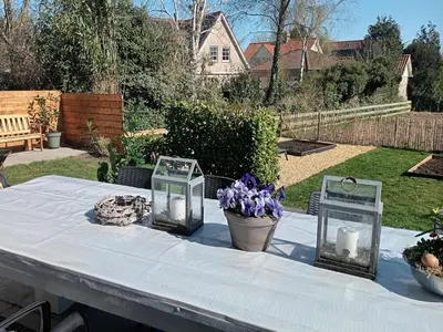 a table with three glass containers and purple flowers on it at Groet Villa Stay with Garden Views in Groet