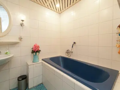 a bathroom with a blue tub and a sink at Holiday Home in Schoorl near Forest & Beach in Schoorl