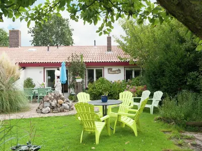 a table and chairs in the yard of a house at Holiday Home in Schoorl near Forest & Beach in Schoorl