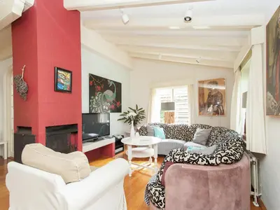 a living room with white furniture and a red wall at Holiday Home in Schoorl near Forest & Beach in Schoorl
