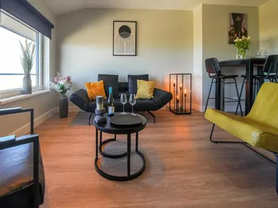 a living room with couches and a table with wine glasses at Apartment in Katwijk near the Beach in Katwijk