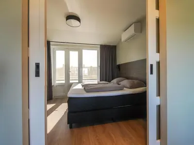 a bedroom with a bed and a window at Apartment in Katwijk near the Beach in Katwijk