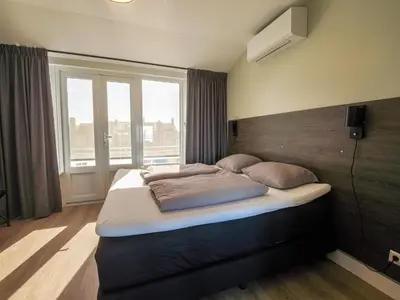 a large bed in a room with a window at Apartment in Katwijk near the Beach in Katwijk