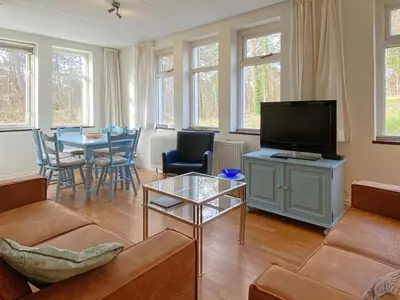 a living room with a couch and a tv at Skyscraper apartment on the highest point with beautiful view in Bergen aan Zee