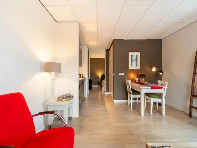 a living room with a red chair and a table at Apartment in Bergen near Sandy Beaches in Bergen