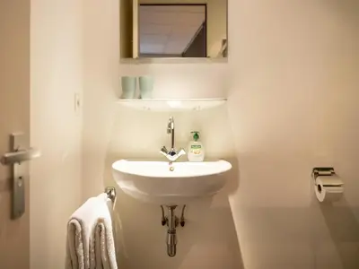 a white bathroom with a sink and a mirror at Apartment in Bergen near Sandy Beaches in Bergen