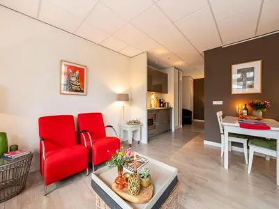 a living room with red chairs and a table at Apartment in Bergen near Sandy Beaches in Bergen