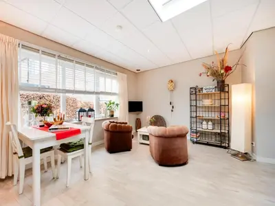 a dining room with a white table and chairs at Apartment in Bergen near Schoorl Dunes in Bergen