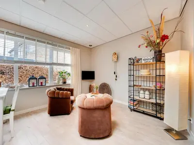 a living room with two chairs and a table at Apartment in Bergen near Schoorl Dunes in Bergen