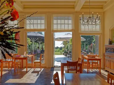 a dining room with tables and chairs and windows at Apartment in Bergen aan Zee near the Beach in Bergen aan Zee