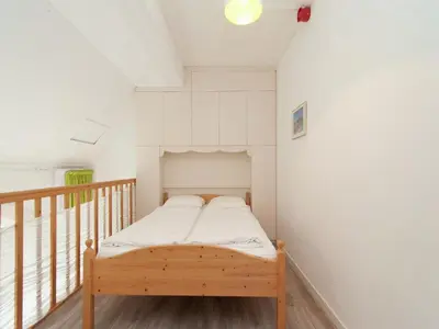 a small bedroom with a bed on a balcony at Apartment in Bergen aan Zee near the Beach in Bergen aan Zee
