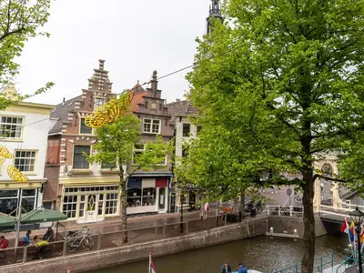 a canal in a city with buildings next to a river at Wolf Hotel Kitchen & Bar in Alkmaar
