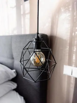 a black geometric pendant light hanging over a couch at Wolf Hotel Kitchen & Bar in Alkmaar