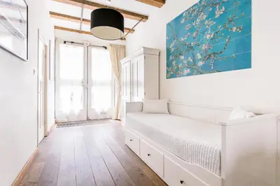 a white room with a bed and a painting on the wall at GH Amsterdam in Amsterdam