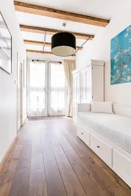a white bedroom with a bed and a large window at GH Amsterdam in Amsterdam