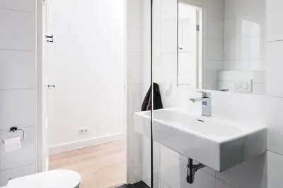 a white bathroom with a sink and a mirror at GH Amsterdam in Amsterdam