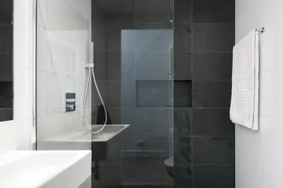 a bathroom with a glass shower with a sink at GH Amsterdam in Amsterdam