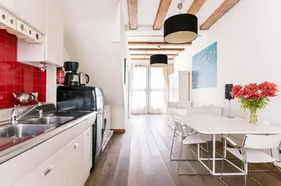 a kitchen with white cabinets and a white table at GH Amsterdam in Amsterdam