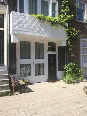 a house with a white door and a bench at GH Amsterdam in Amsterdam