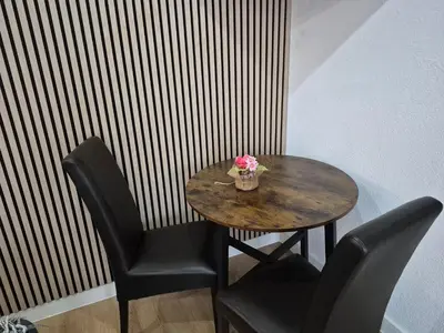 a table with two chairs and a vase of flowers on it at Studio Slijterij Zandvoort in Zandvoort