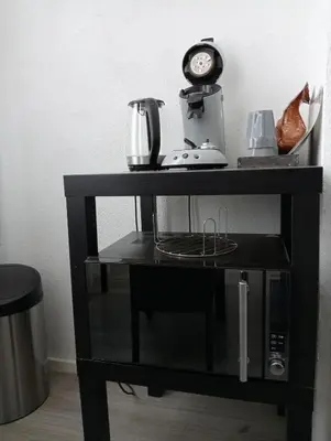 a black shelf with a blender and a clock on it at Studio Slijterij Zandvoort in Zandvoort