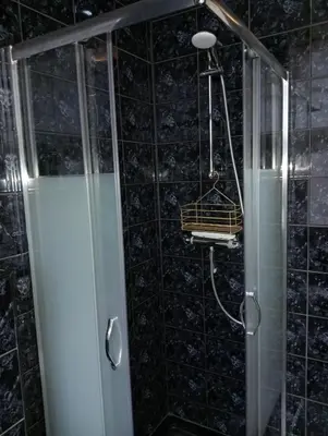 a shower with a glass door and a basket in a bathroom at Studio Slijterij Zandvoort in Zandvoort