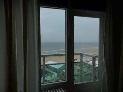 a room with two windows looking out at an airport at Dreamview Apartment in Zandvoort