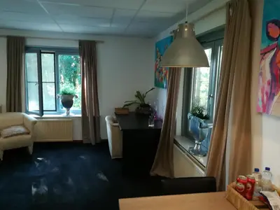 a living room with a couch and a window at Appartement De Molshoop II in Landsmeer