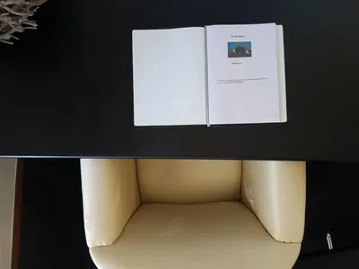 a book sitting on top of a table with a chair at Appartement De Molshoop II in Landsmeer
